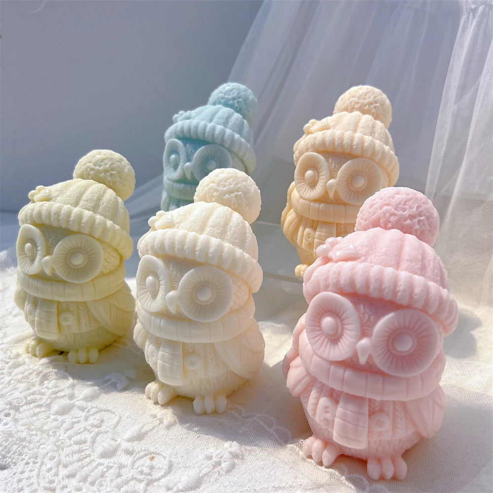 Angled view of pink, cream and green owl candles showing ribbed winter hats
