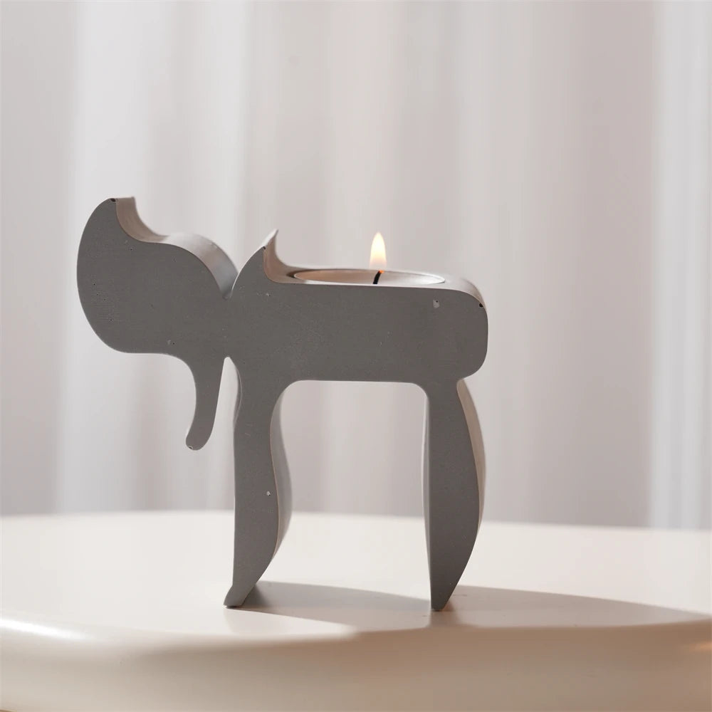 Single gray Chai candle holder with open frame and sculpted silhouette