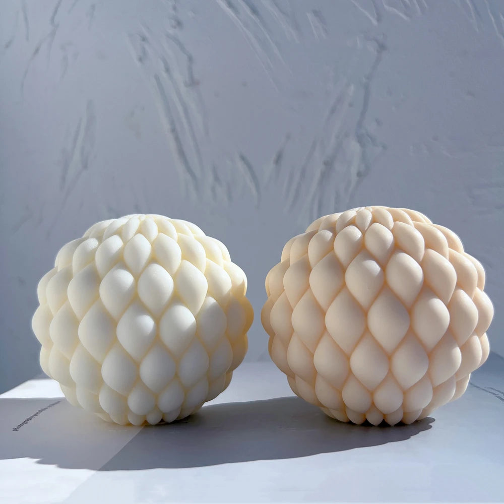 Cream and peach scale-textured ball candles side by side