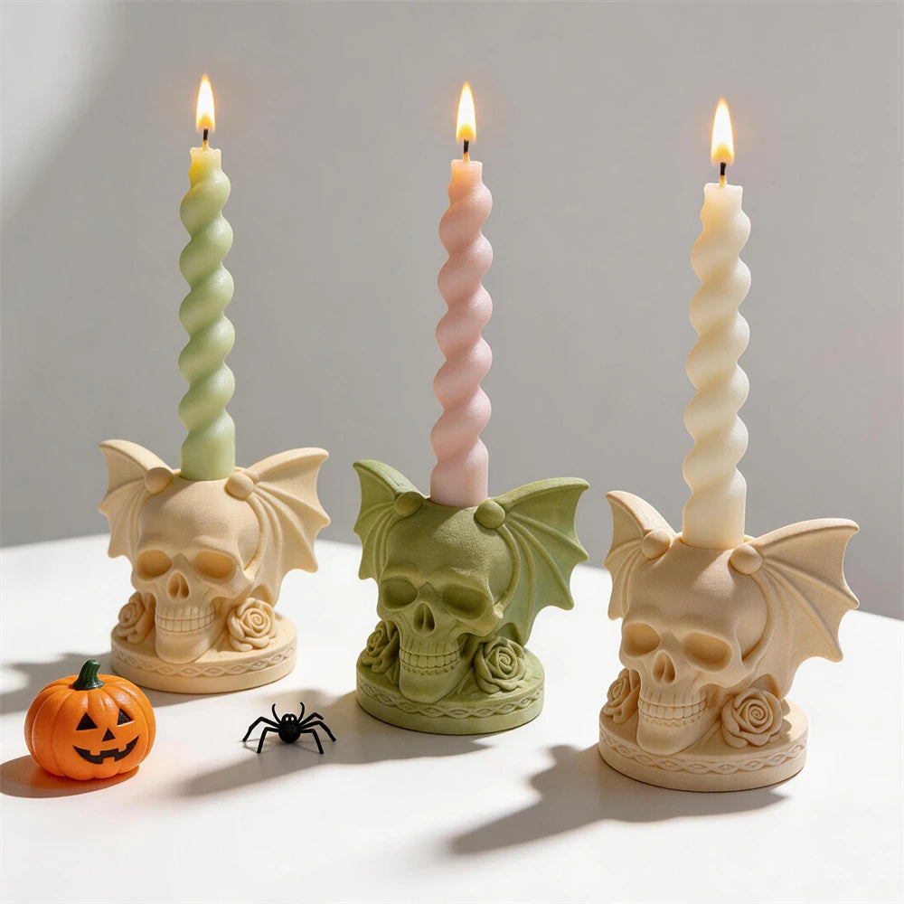 Three bat-wing skull holder castings with taper candles