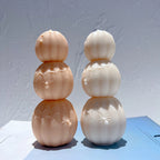 Two three-tier pumpkin candles showing web and spider details