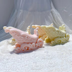 Close angled view of pink and yellow sleigh castings with curled runners