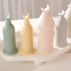 Four tall and short crescent-finial pillar candles in pastel colors on a display tray