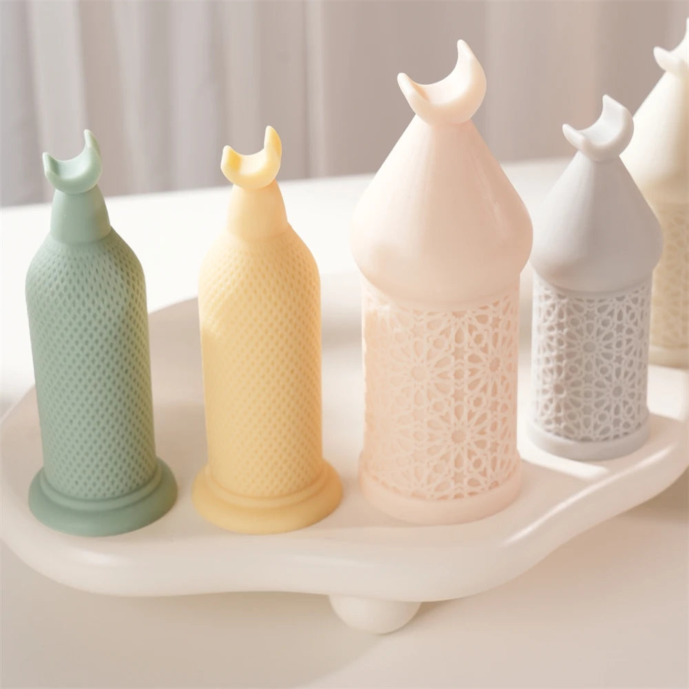 Four tall and short crescent-finial pillar candles in pastel colors on a display tray
