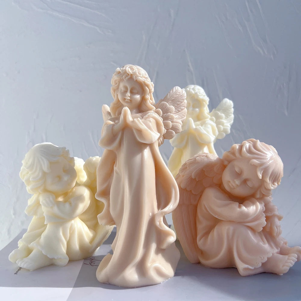 Standing praying angel and seated cherub candle castings with feathered wings