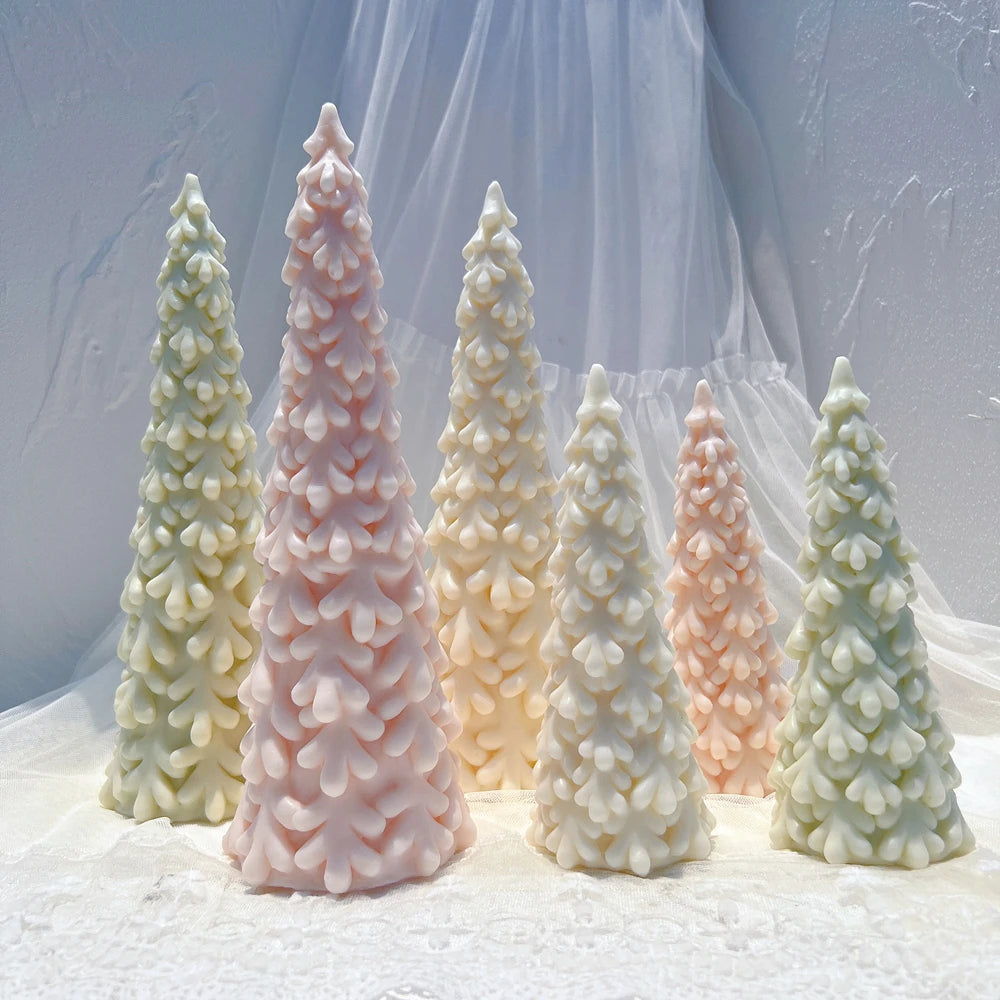 Snowy pine Christmas tree candles in different heights and pastel colors