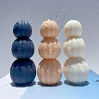 Three pumpkin towers in navy peach and cream with spiderweb relief