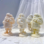 Three Santa figurine castings from the front and side in pale winter colors