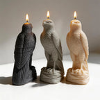 Black gray and cream falcon candles with folded wings on textured bases