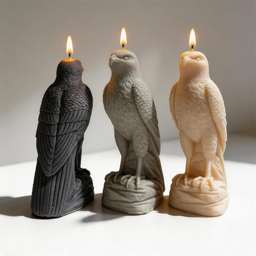 Black gray and cream falcon candles with folded wings on textured bases