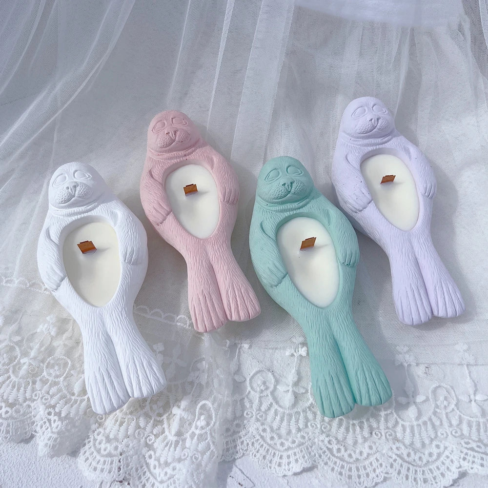 Four seal holder castings with sculpted faces and flippers