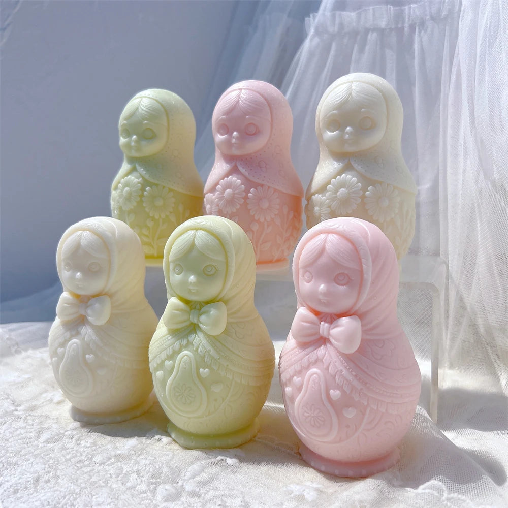 Pastel Russian nesting doll candles with patterned dresses arranged in two rows