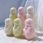 Pastel Russian nesting doll candles with patterned dresses arranged in two rows