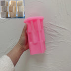 Pink silicone EID tower mold held beside example castings