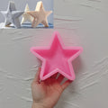 Pink five-point star silicone mold held in one hand with candle examples