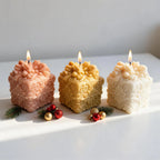 Three decorated gift-box candle castings in warm colors