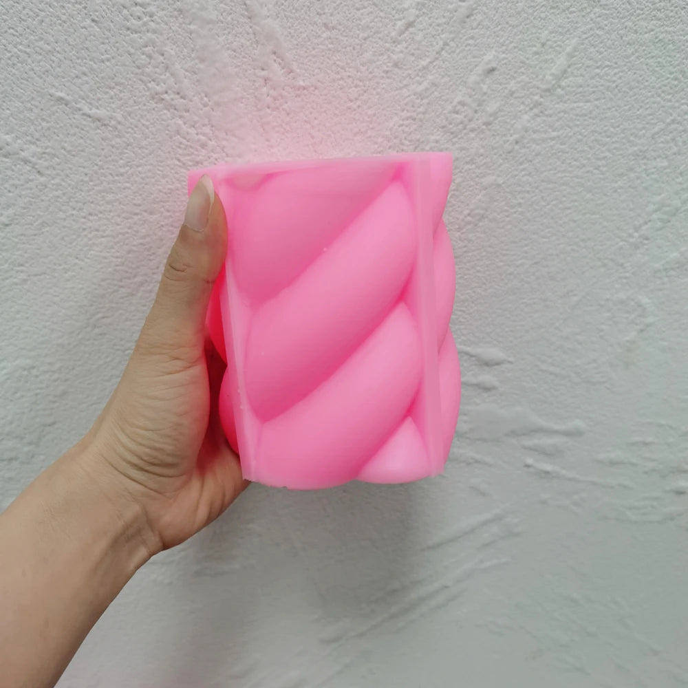 Pink rounded rope-twist silicone mold held in one hand