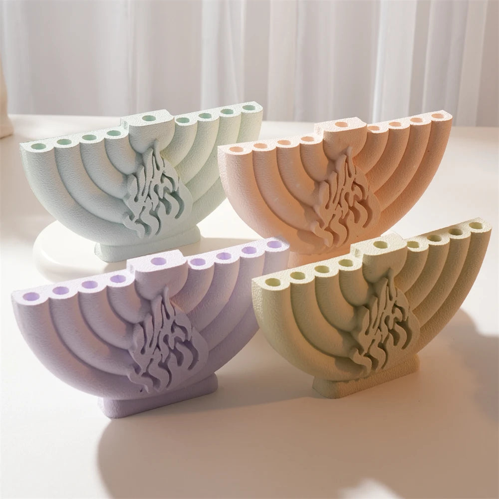 Four decorative Hanukkah menorah castings in cream, terracotta, lavender and olive