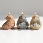 Three seated hedgehog candle figures seen from side and front