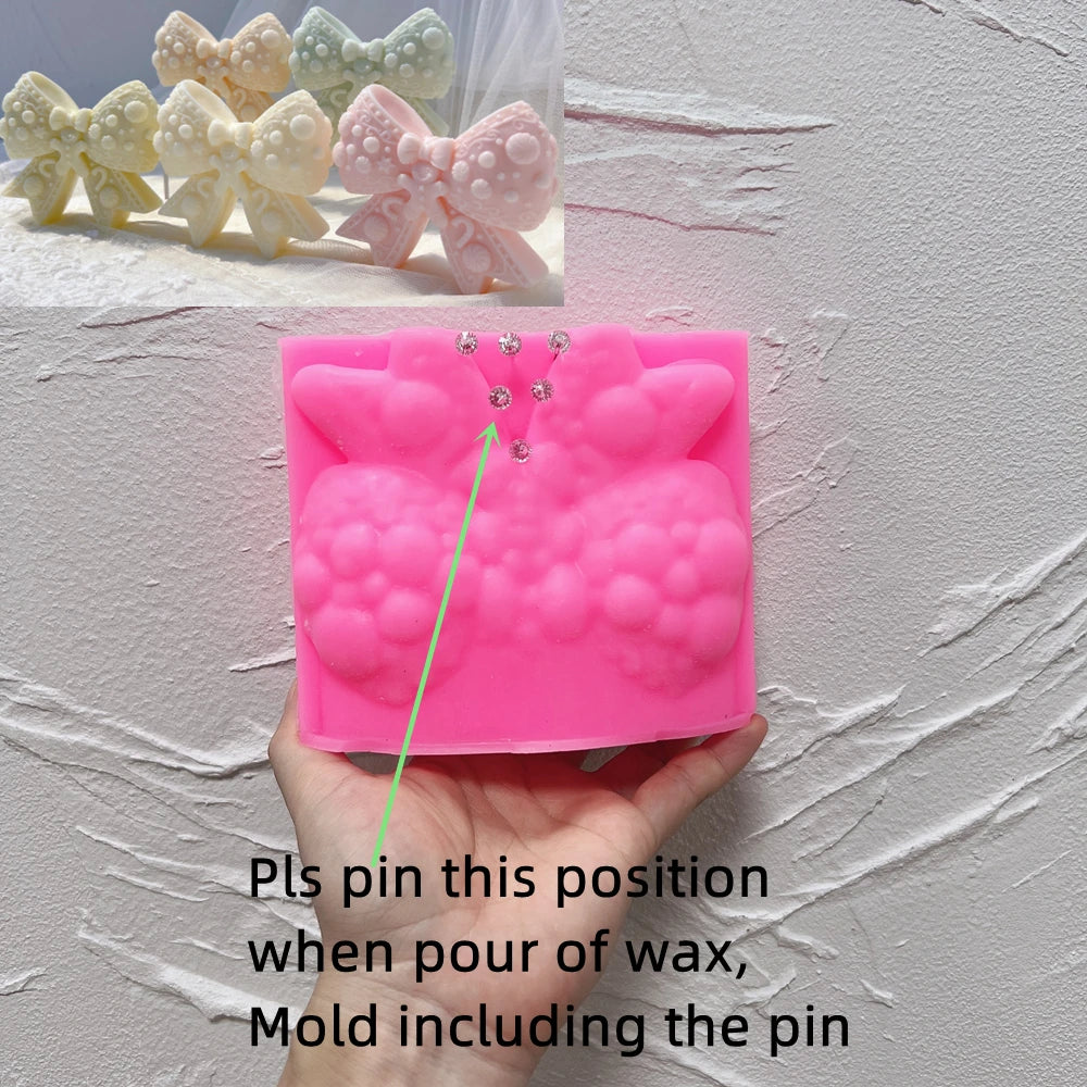 Pink gingerbread bow silicone mold with marked pin placement and included-pin guidance