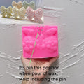 Pink gingerbread bow silicone mold with marked pin placement and included-pin guidance