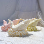 Side view of yellow and cream wax sleighs showing raised scrollwork