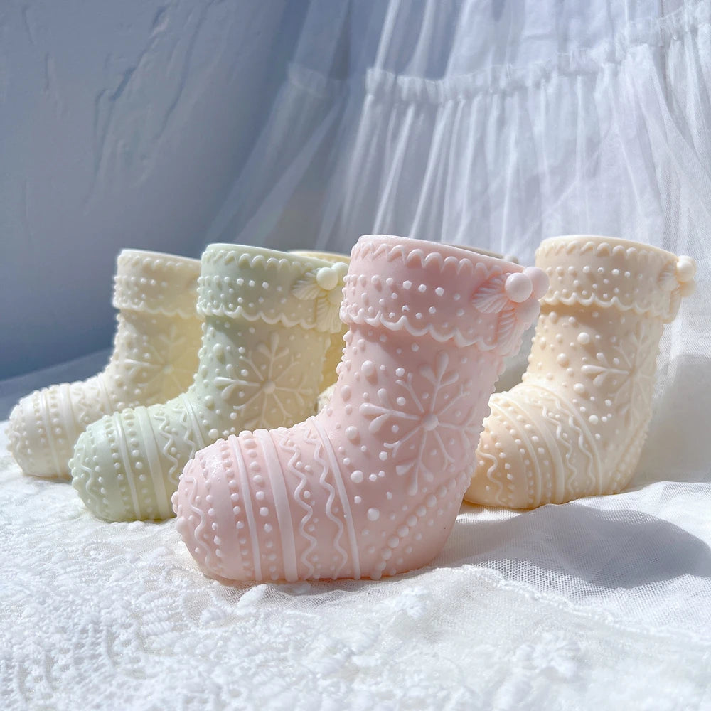 Four stocking-shaped castings with raised festive patterns