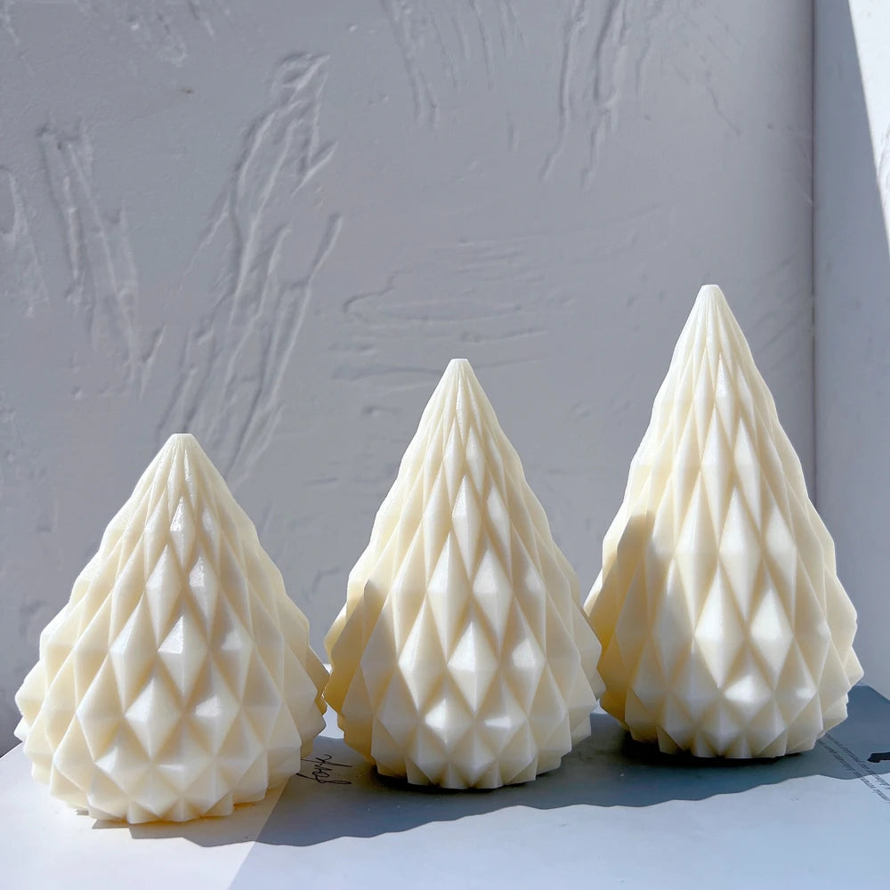 Three diamond-faceted cone candle castings in ascending sizes