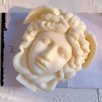 Ivory Medusa face casting framed by coiled snake hair