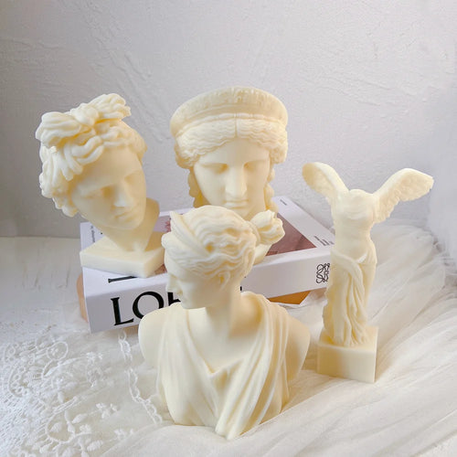 Four cream classical sculptures with detailed hair, drapery and wings