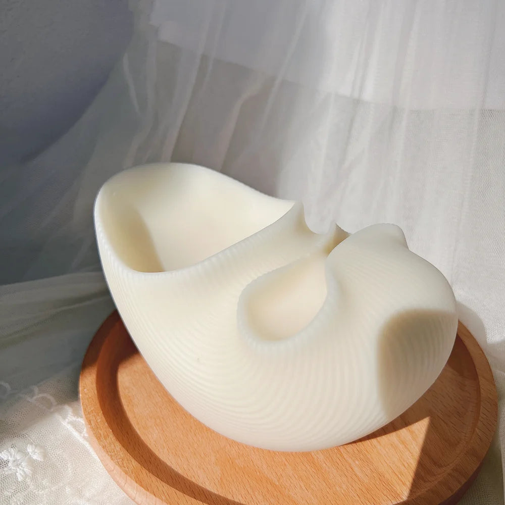 Angled view of sculptural white vessel with two different-sized open recesses