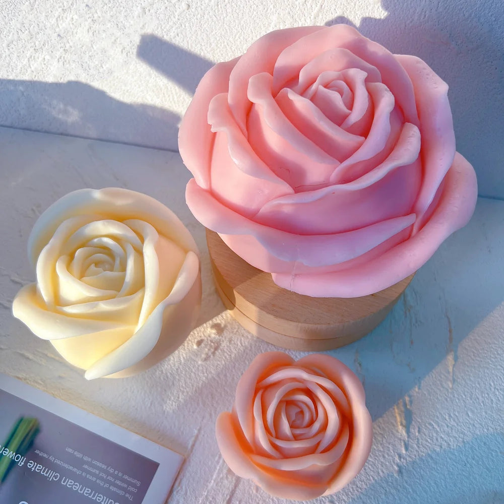 Large pink rose casting beside smaller cream and peach rose blooms