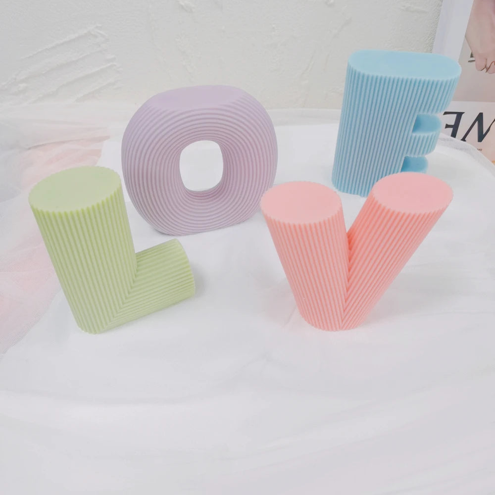 Angled display of green L, lilac O, peach V and blue E castings